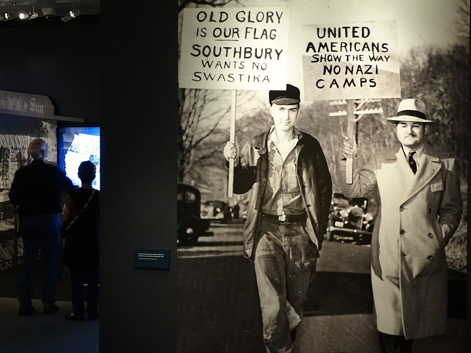 Solemn memorial exhibit with historical artifacts and photographs
