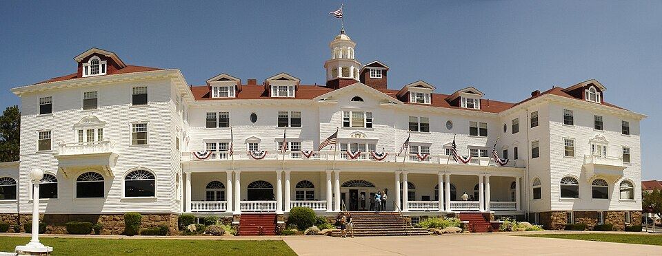 Grand white colonial hotel with mountains behind it