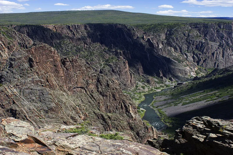 Deep narrow gorge of Black Canyon of the Gunnison with dark rock walls