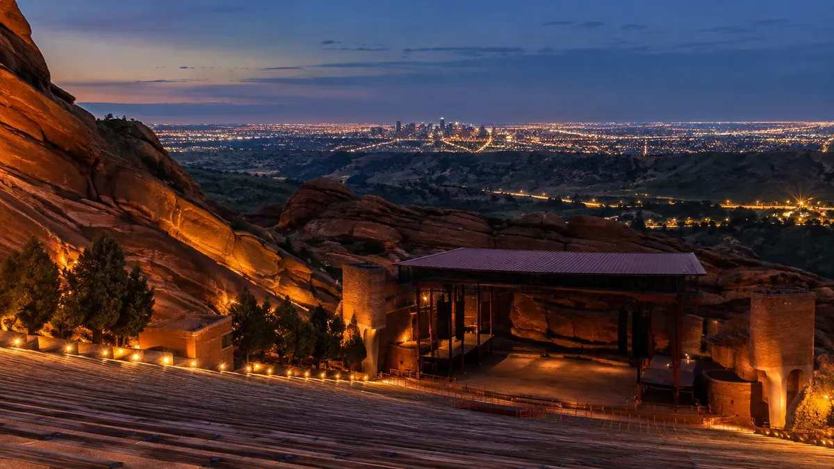 the Denver skyline seen from the top row of Red Rocks Amphitheatre at night