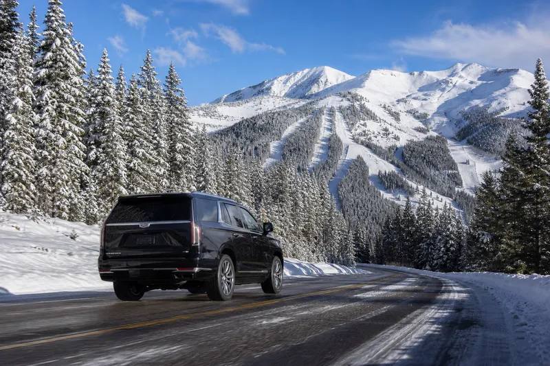 Chauffeured SUV on a snowy highway toward a Colorado ski resort