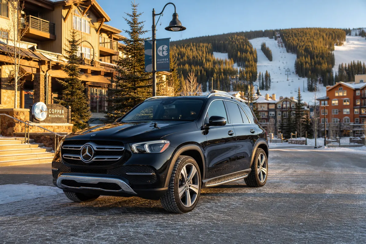 Luxury SUV at Copper Mountain Resort village with ski slopes