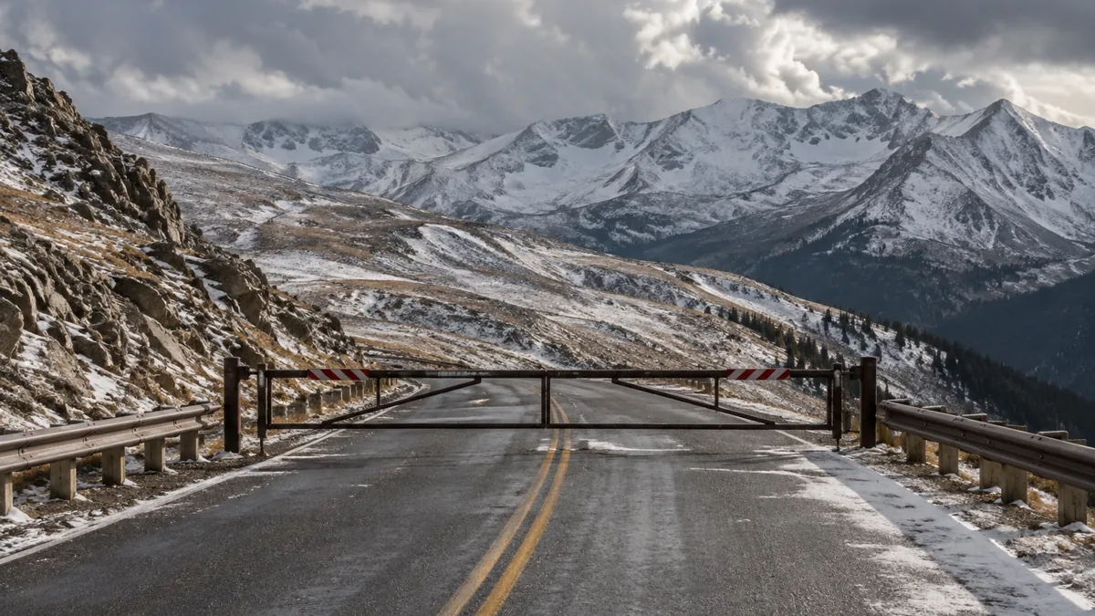 Gate closed across a high alpine pass road in the Colorado Rockies