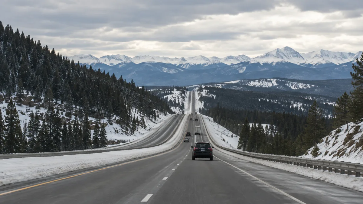 Interstate 25 climbing the open ridge of Monument Hill in winter with snow on the shoulders
