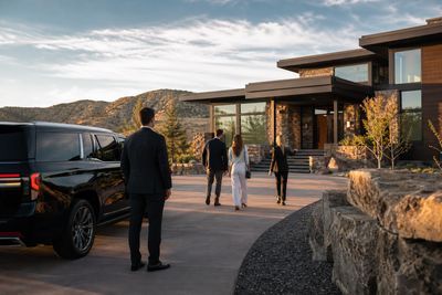 Consulting team boarding a black executive van outside a Denver Tech Center office building