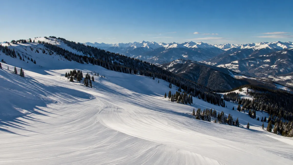 Groomed open bowl on Vail Mountain on a clear morning, ranges layered to the south