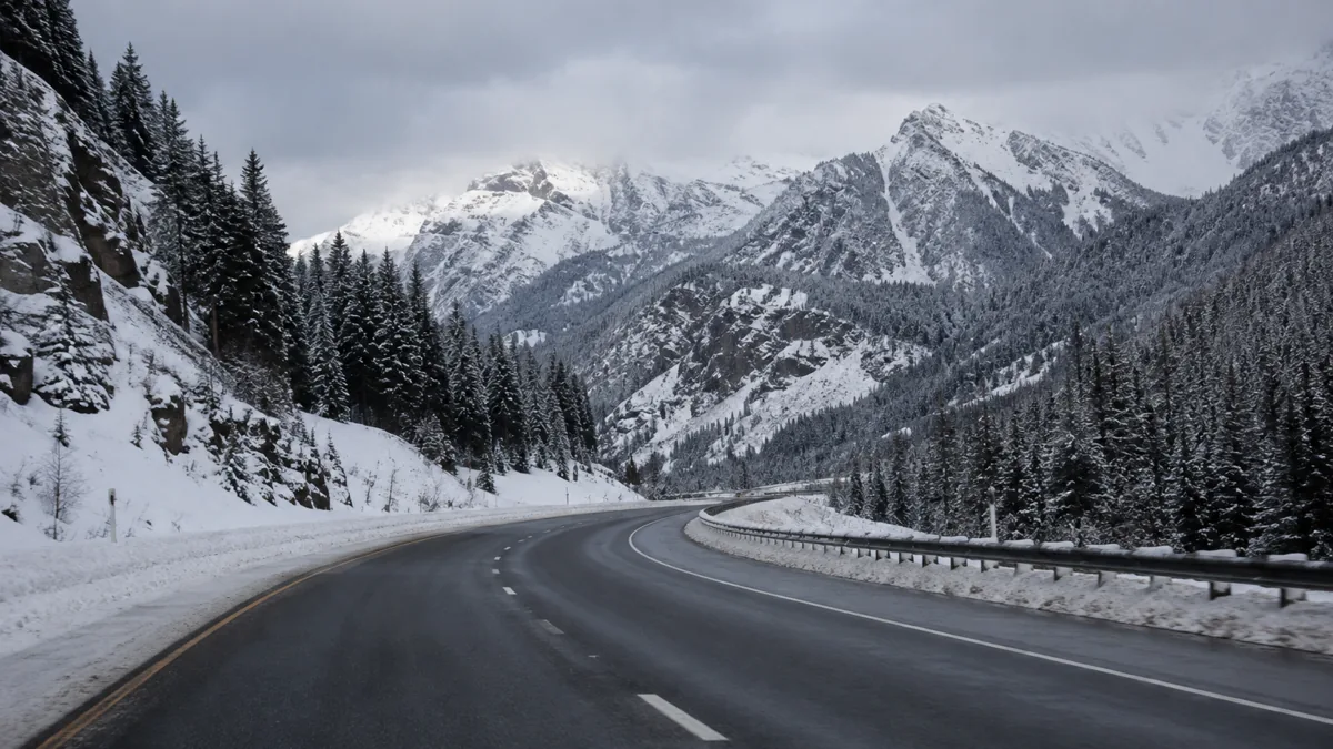 Plowed I-70 curving through a snow-covered pass in the Colorado high country